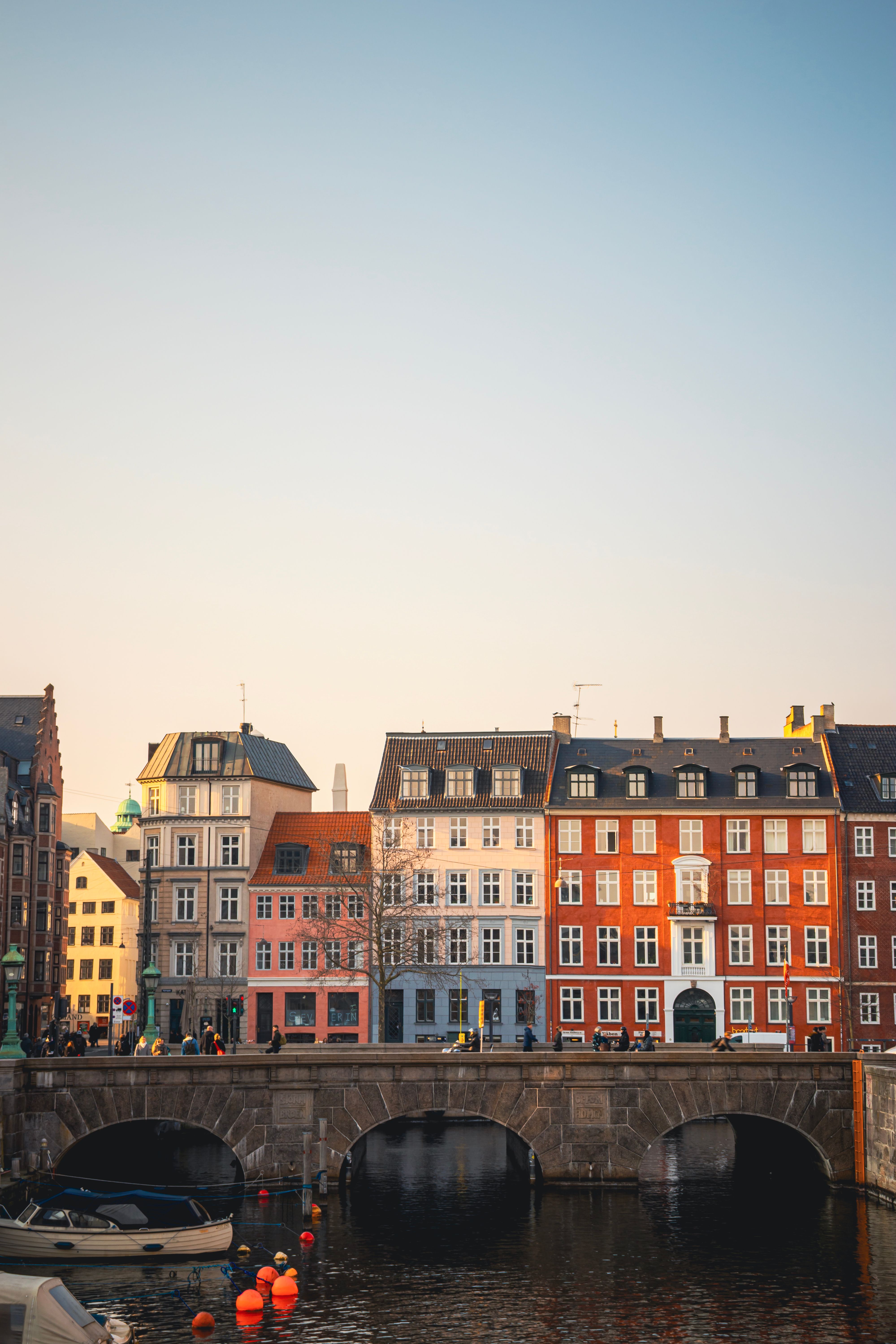 Vibrant historic buildings by the canal in Copenhagen at sunset, showcasing classic Danish architecture.