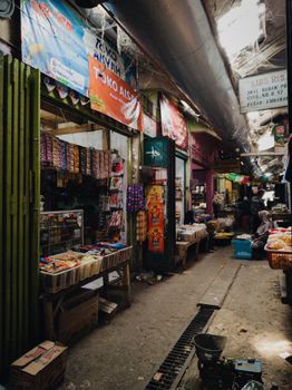Traditional market aisle in Jakarta with colorful stalls and fresh produce, showcasing vibrant local culture. - Fotografer Sidoarjo