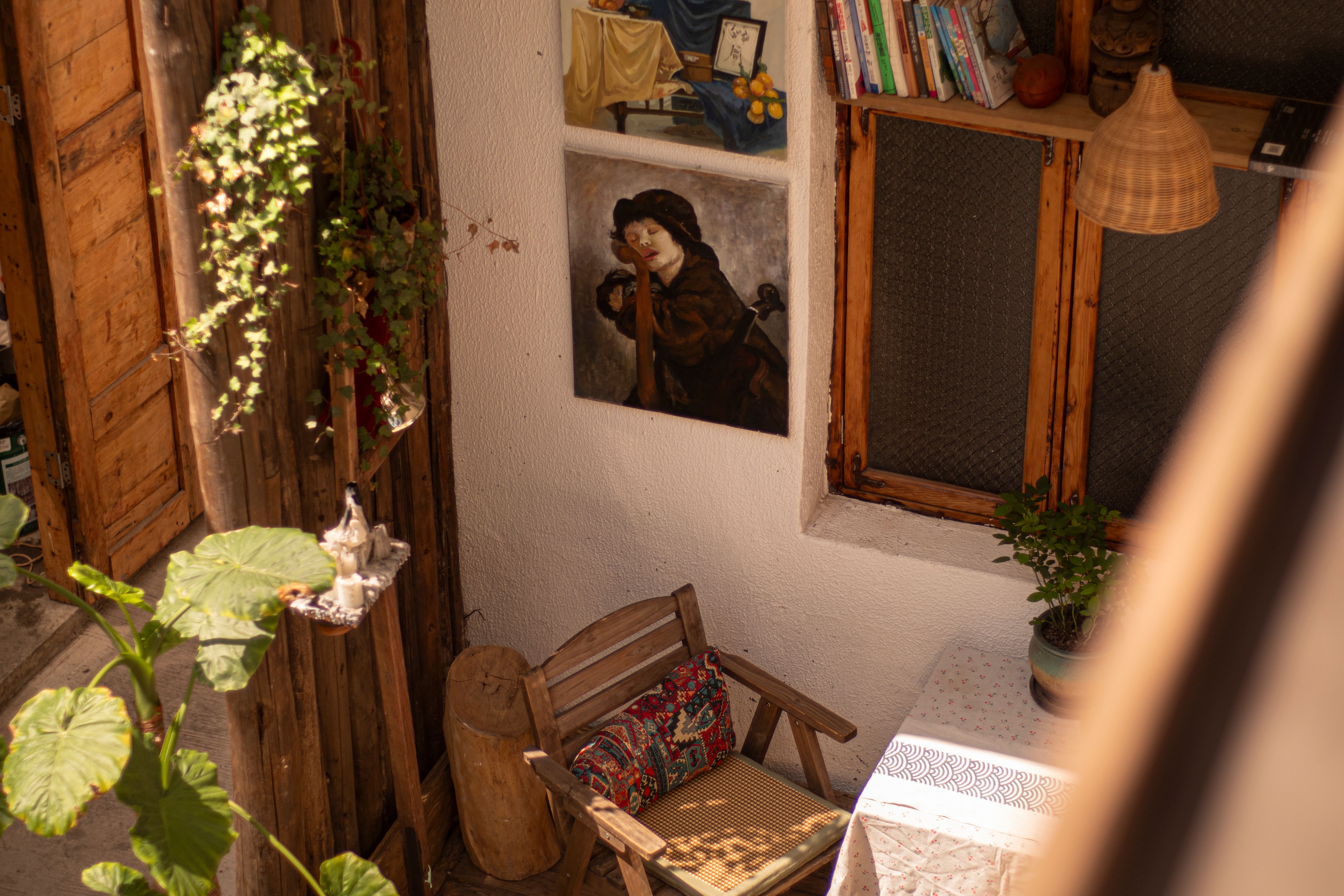 A warm, inviting indoor space featuring rustic decor, vibrant plants, and artwork.