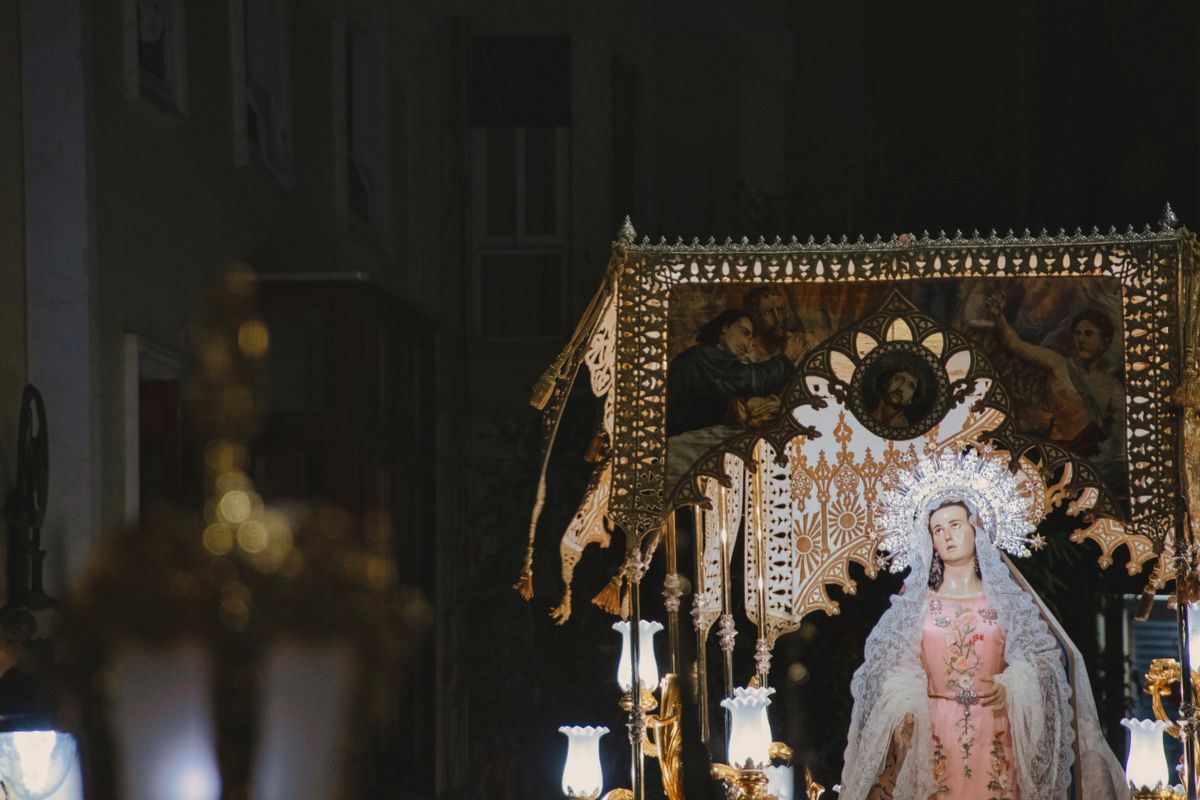 Statuia Fecioarei sub un baldachin brodat auriu, iluminata noaptea