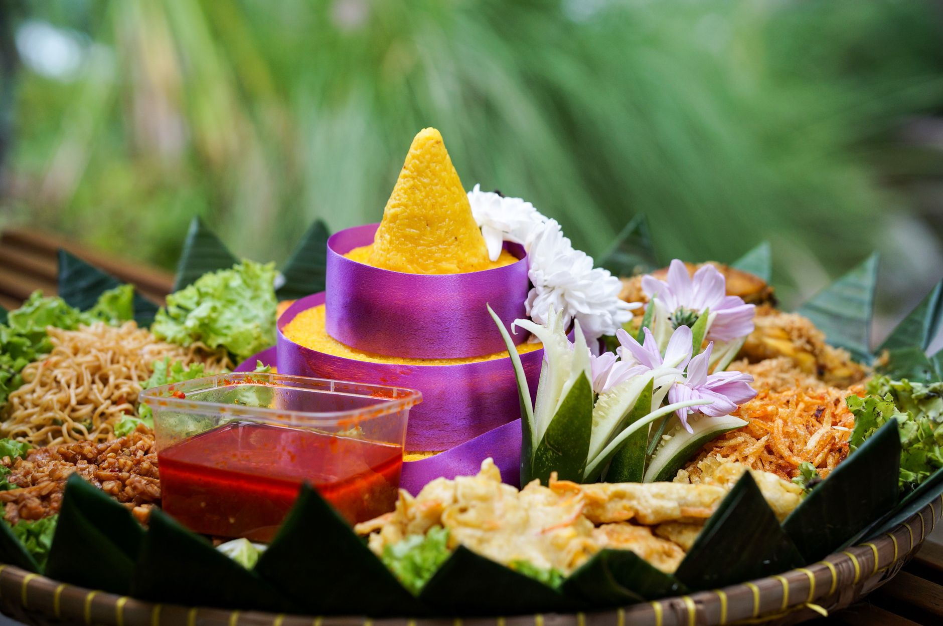 Colorful tumpeng rice served with vibrant garnishes and side dishes, perfect for festive occasions.