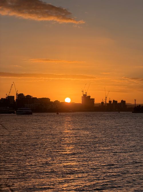 Free Stunning sunset over Newcastle Harbour, silhouette of cityscape and cranes with vibrant orange sky. Stock Photo