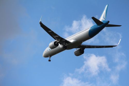 Free A commercial airplane flying against a clear blue sky, photographed in Amsterdam, Netherlands. Stock Photo