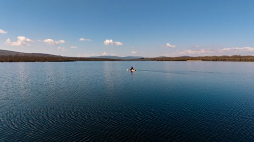 Free A lone kayaker paddles across a tranquil lake under a clear sky in Zamora, Spain. Stock Photo