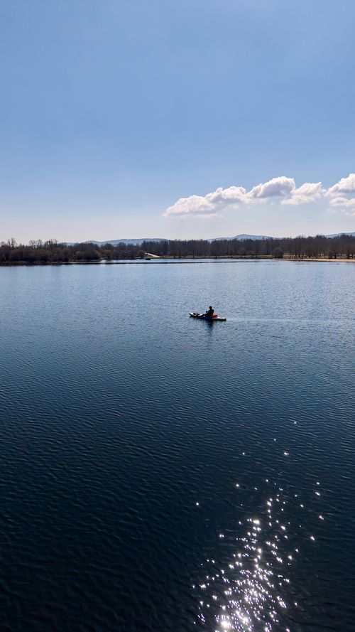 Free A lone kayaker on a tranquil lake in Zamora, Spain, under blue skies. Stock Photo
