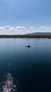A lone kayaker navigating a calm lake in Zamora, Spain, under a clear blue sky