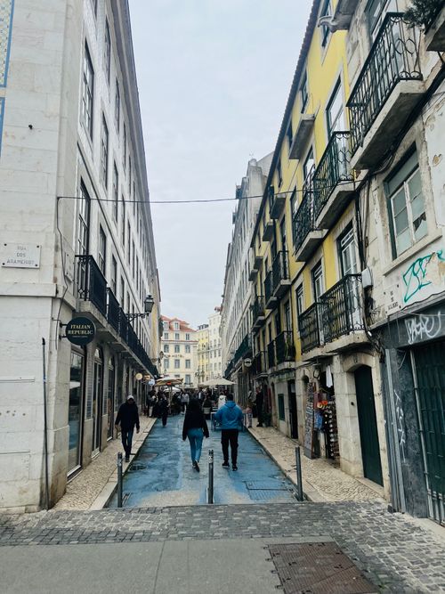 Free Charming street view in Lisbon with colorful buildings and pedestrians. Stock Photo