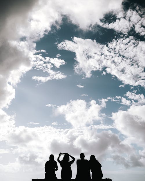 Silhouette of People Sitting and Looking at Blue Cloudy Sky