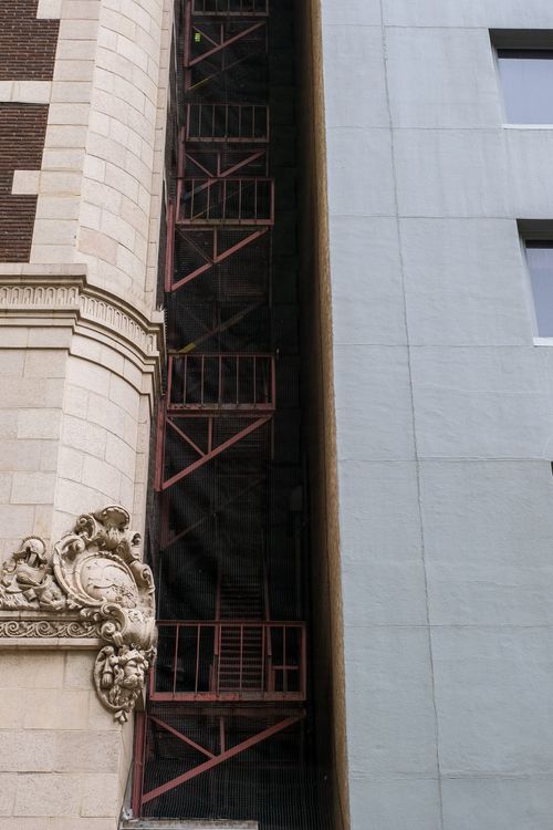 Free Detailed view of urban architecture with decorative facade and fire escape staircase. Stock Photo