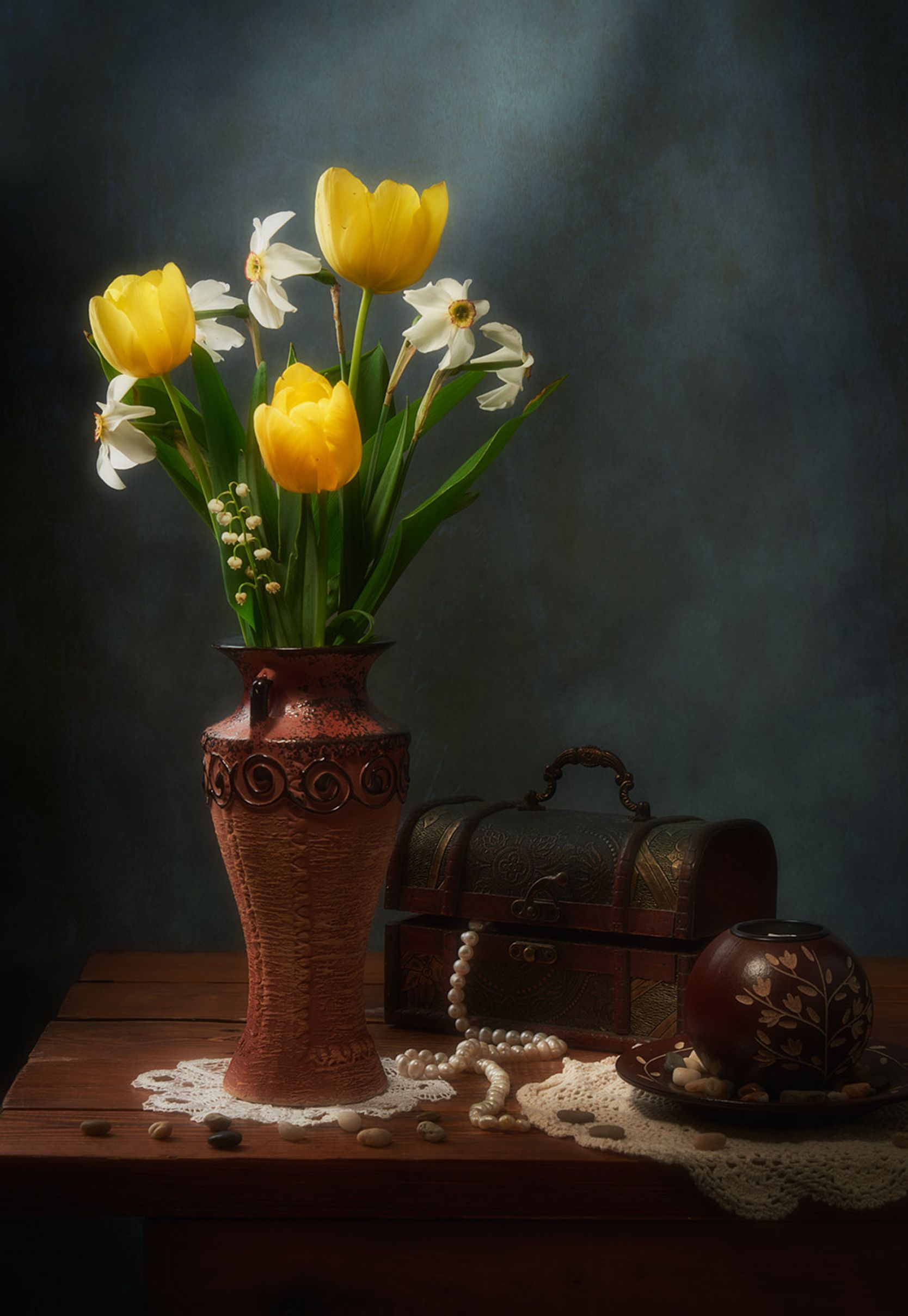 A sophisticated still life depicting tulips and daffodils in a vase alongside delicate tableware.