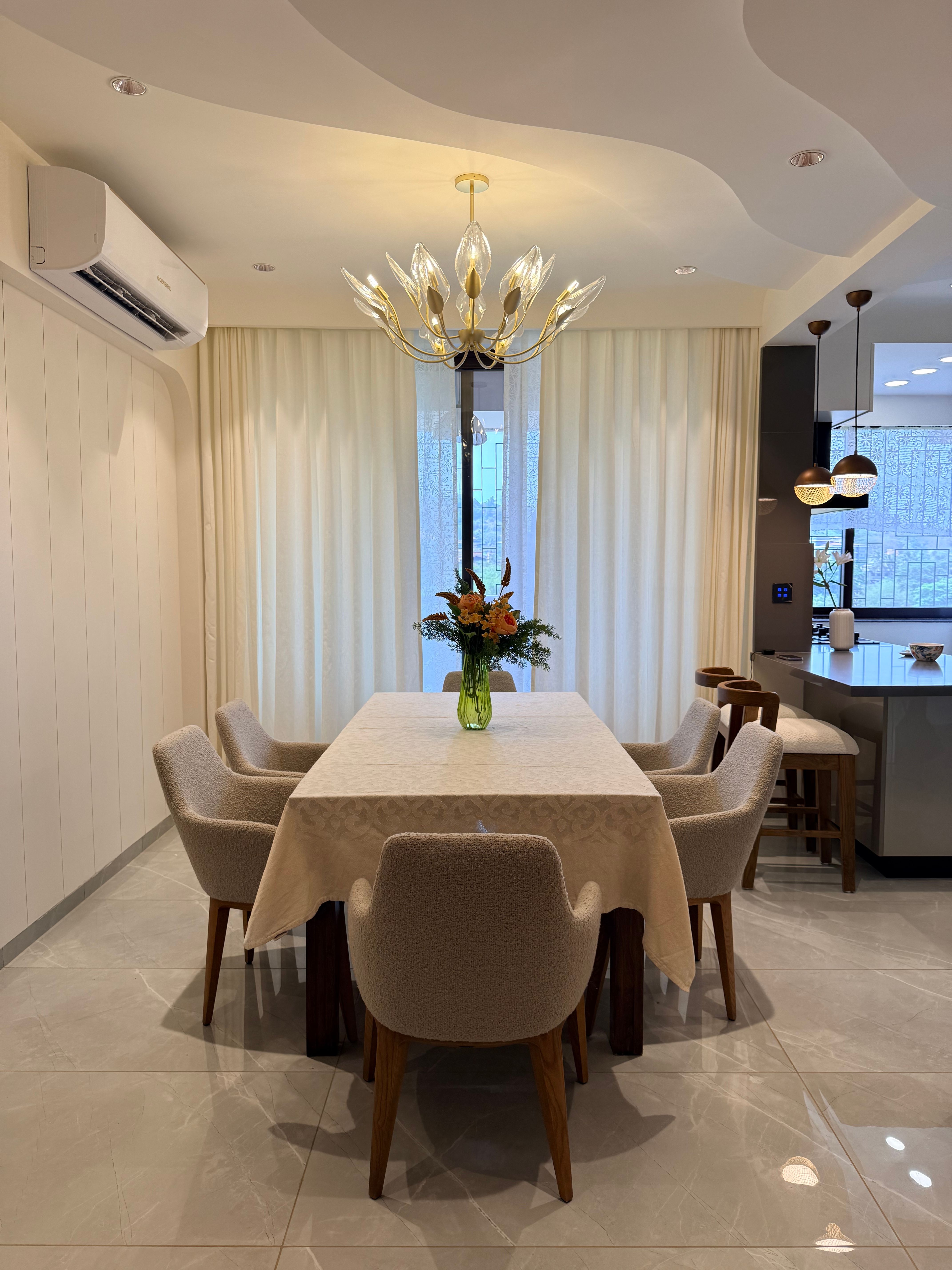 Sophisticated dining area featuring plush seating and contemporary chandelier.