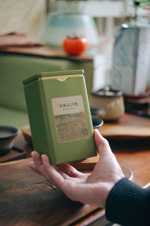 Free A hand holds a green tea tin in an elegant Asian tea room setting. Stock Photo