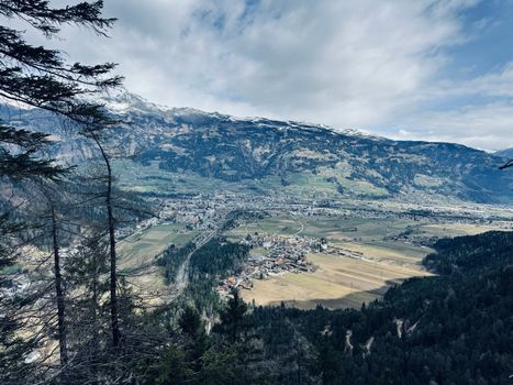 Aerial view of a picturesque mountain valley surrounded by lush forests and scattered villages.