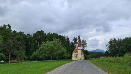 Free A picturesque church located amidst lush greenery and cloudy skies in rural Austria. Stock Photo