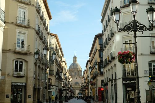Free Explore the historic architecture of Zaragoza's vibrant street with a view of the Basilica de Nuestra Señora del Pilar. Stock Photo