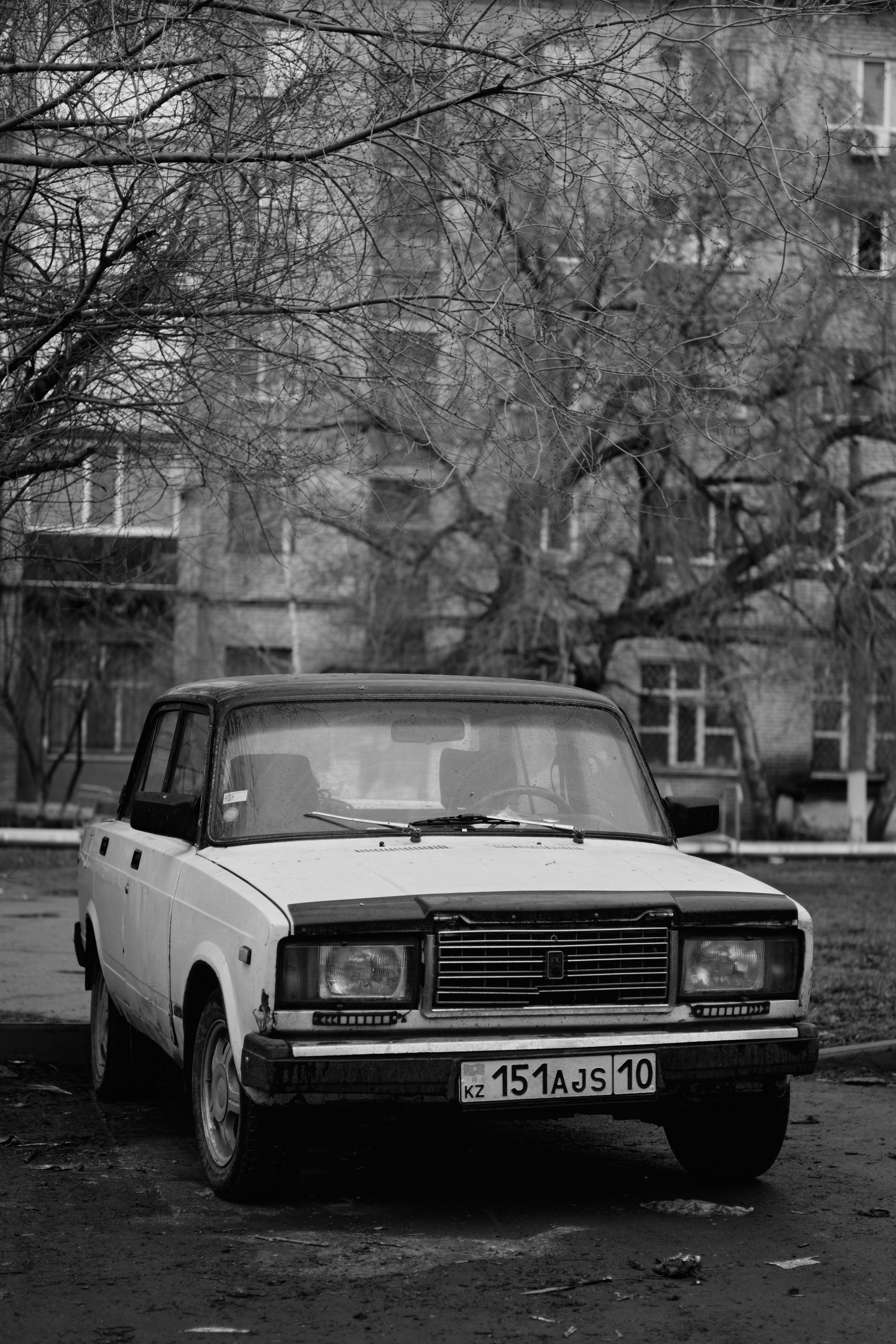 Black and white photo of a classic Soviet-era car parked in a city street.