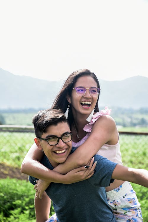 Photo of Man Carrying a Woman While Laughing