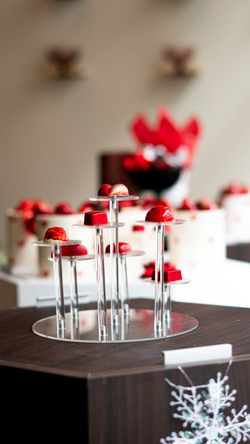 Free Artistic dessert display featuring red pastries on a tiered stand, perfect for celebrations. Stock Photo