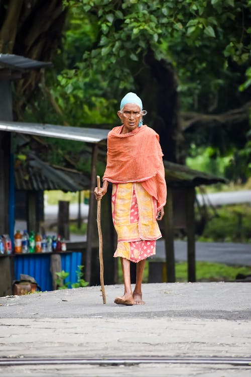 Photo Of An Old Woman Walking Barefoot