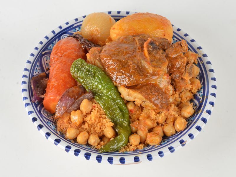 A vibrant plate of Moroccan couscous featuring tender lamb, vegetables, and chickpeas.