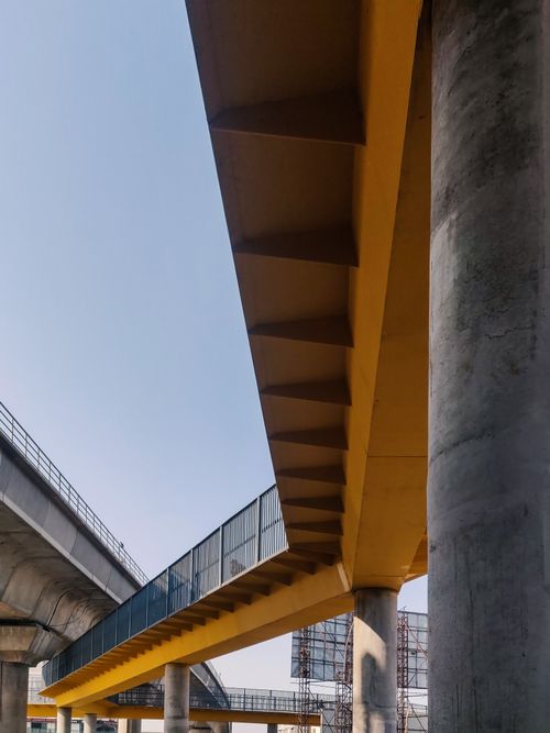Free A striking yellow bridge structure under a clear blue sky, highlighting modern architecture. Stock Photo