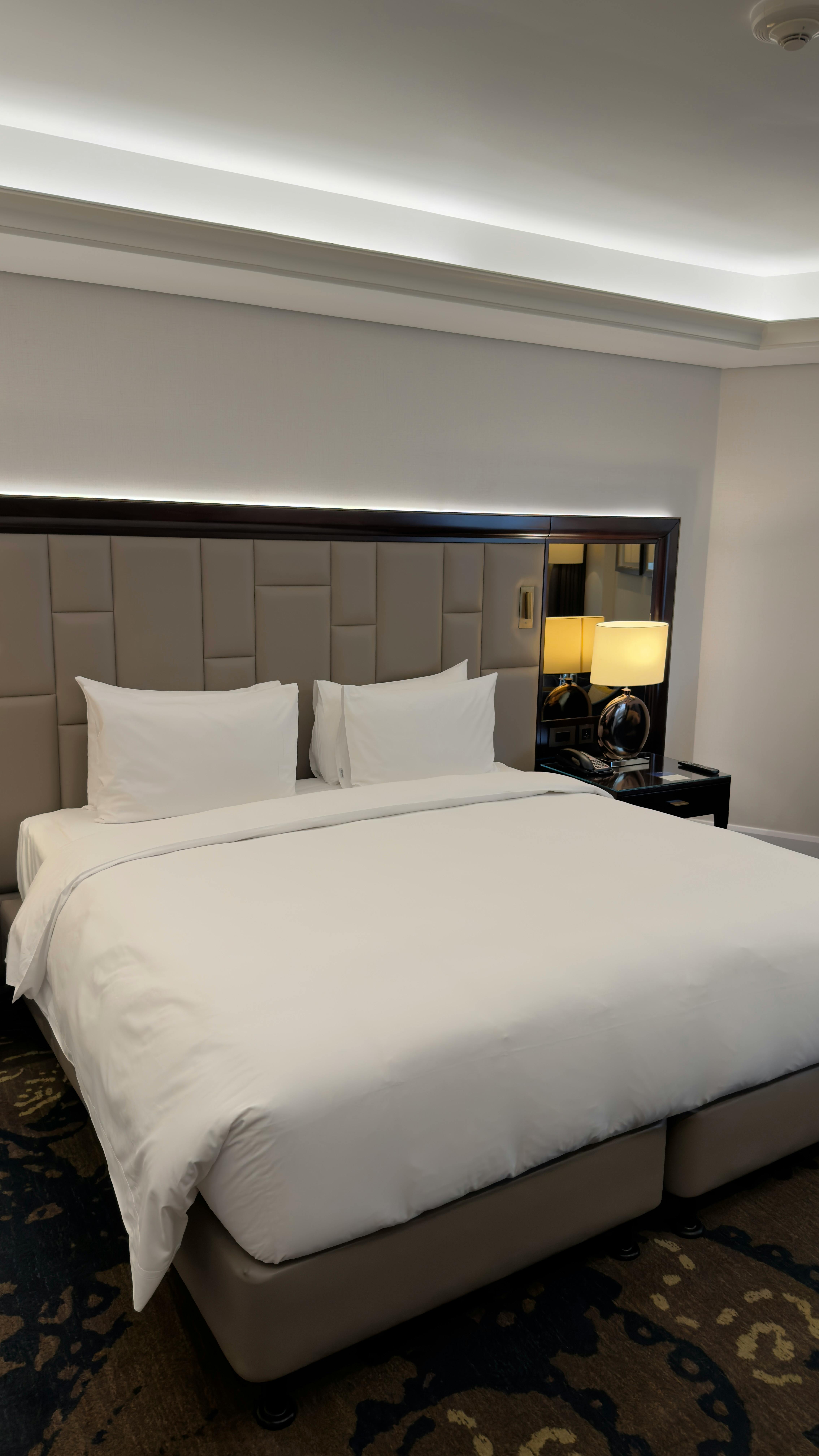 Spacious hotel room featuring a large bed and stylish decor, ideal for travelers seeking comfort.