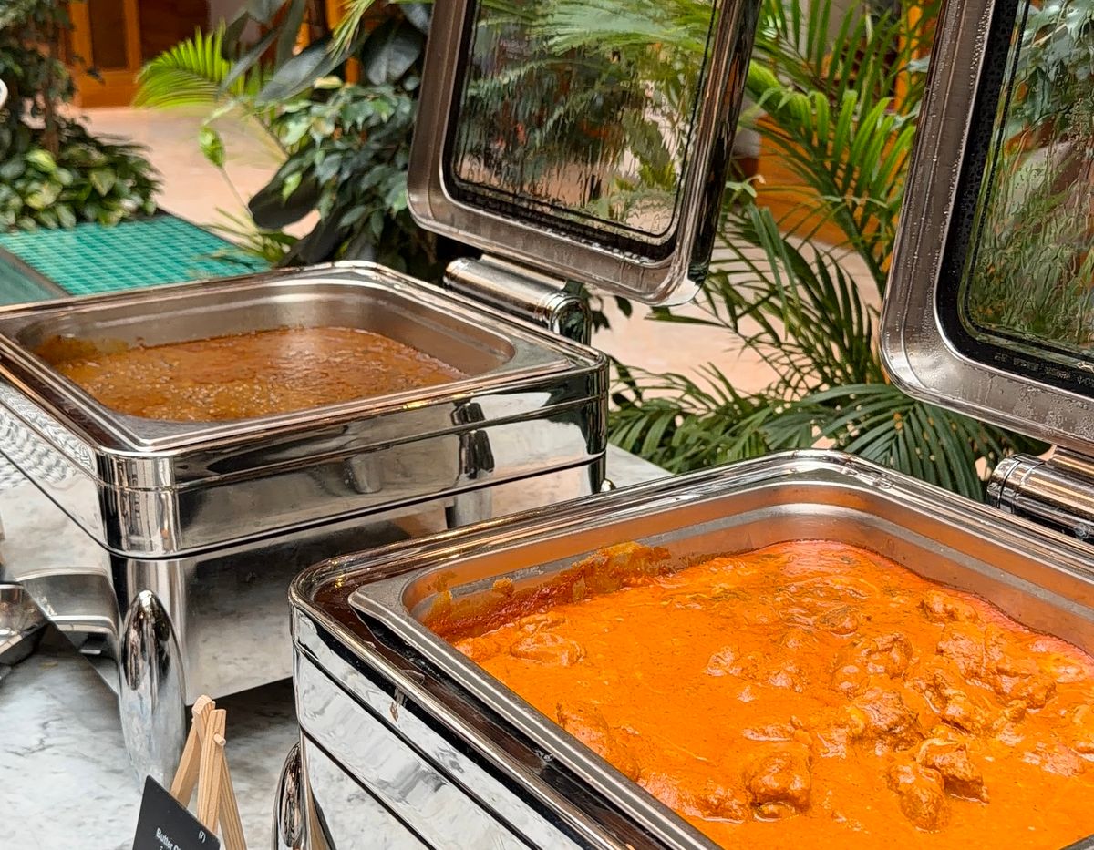 Buffet counter with stainless steel chafing dishes and greenery