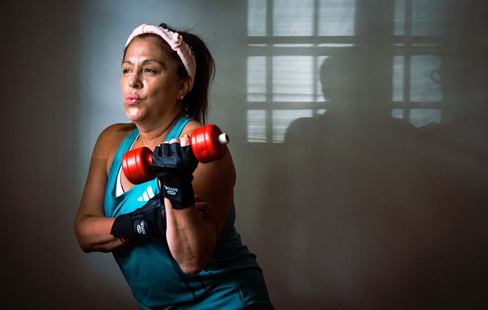 Middle-aged woman lifting a dumbbell during strength training.