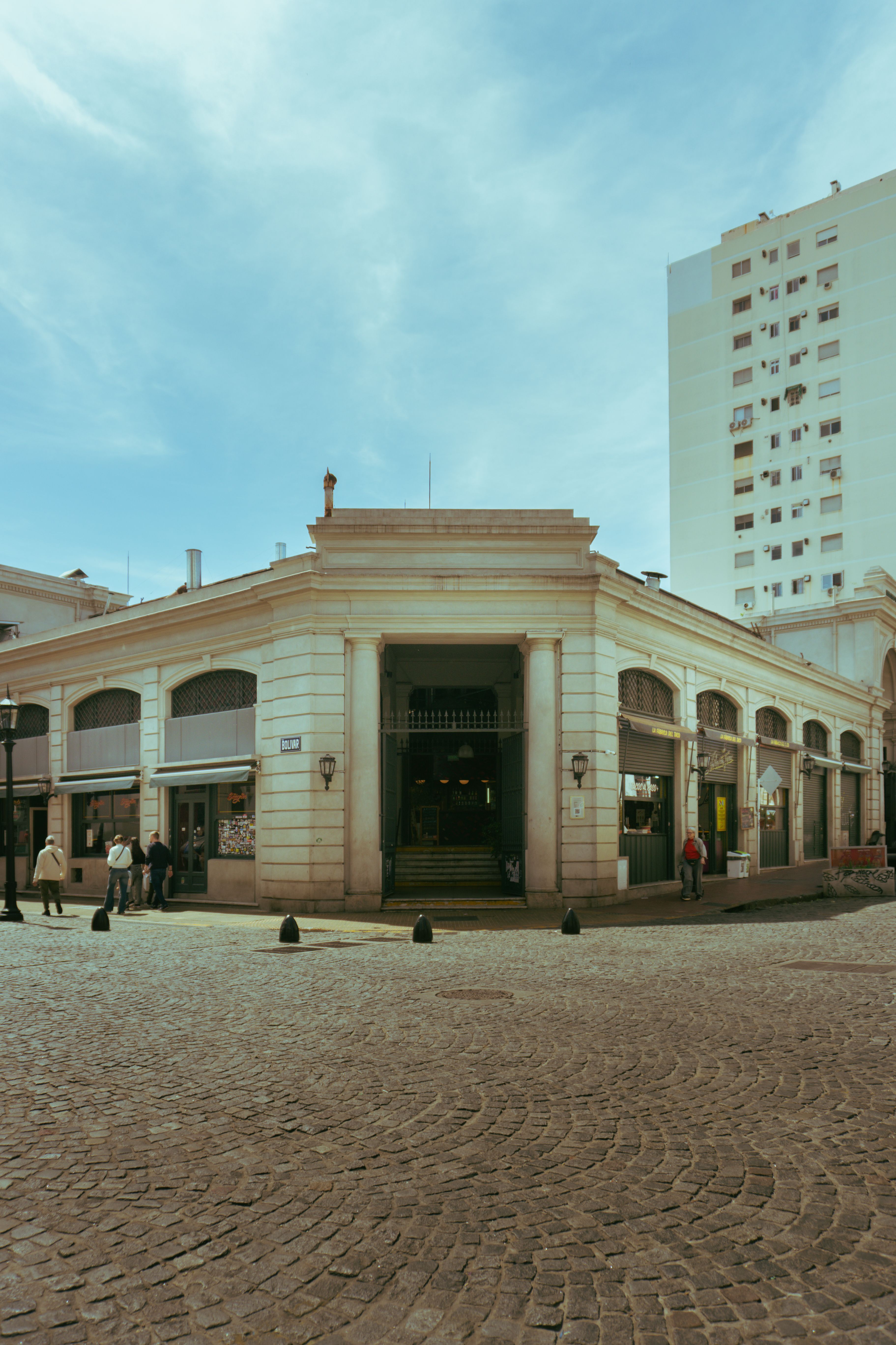 San Telmo market building with people outside under a clear blue sky, capturing urban ambiance.