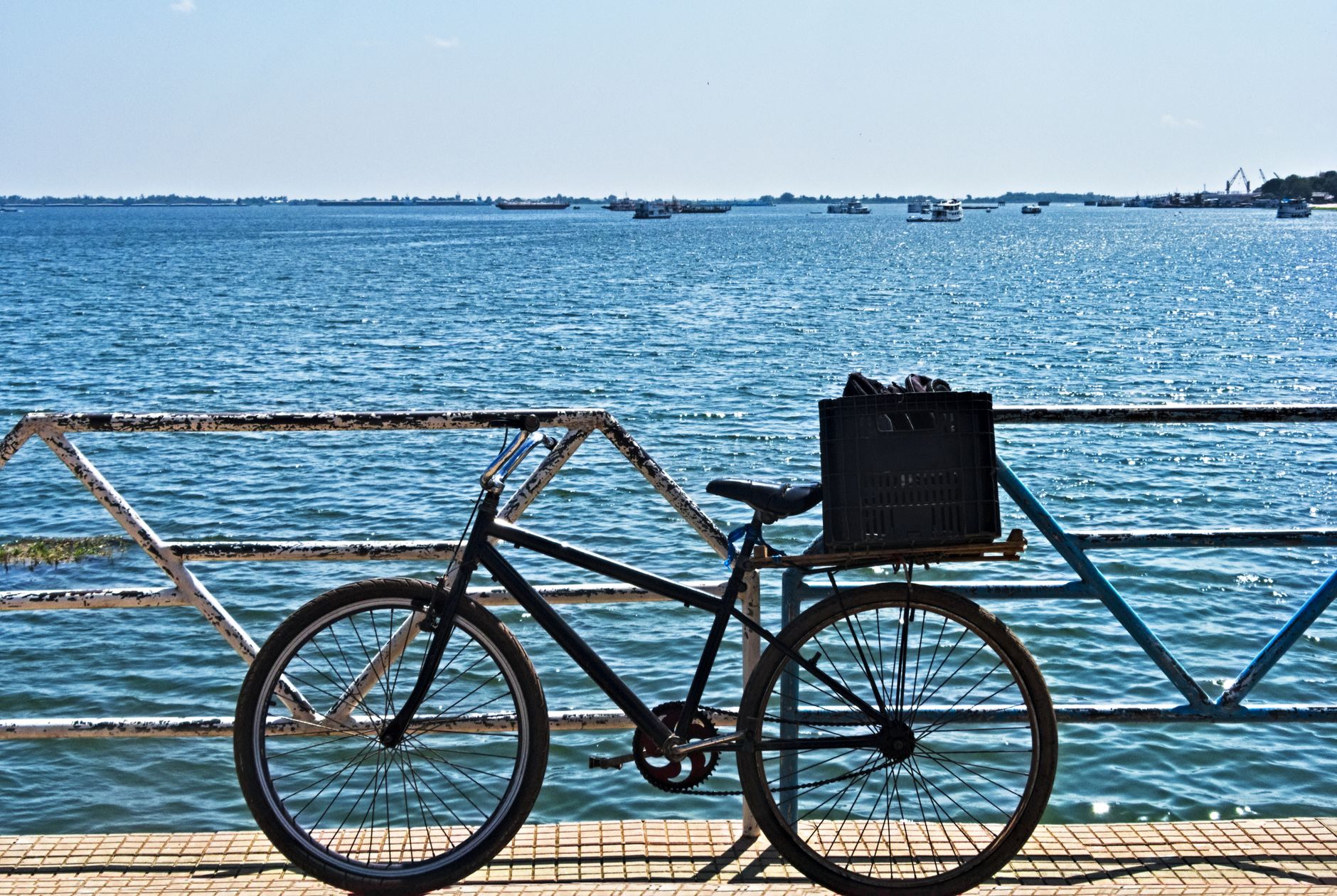 A bicycle with a basket on Santarém waterfront, Pará, Brazil, under a clear sky.