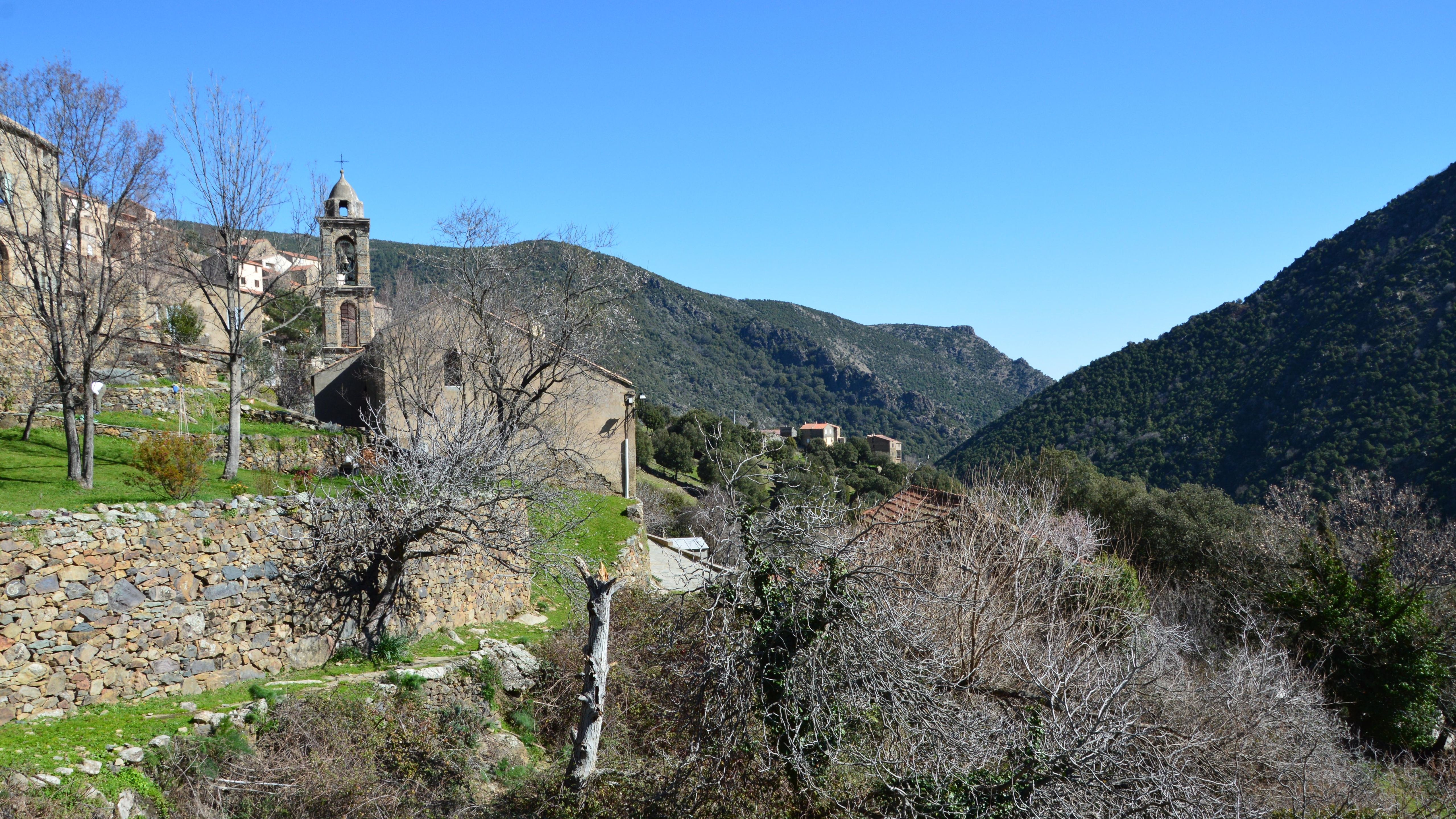 Scenic view of Asco village with church and mountains in Corsica, France.