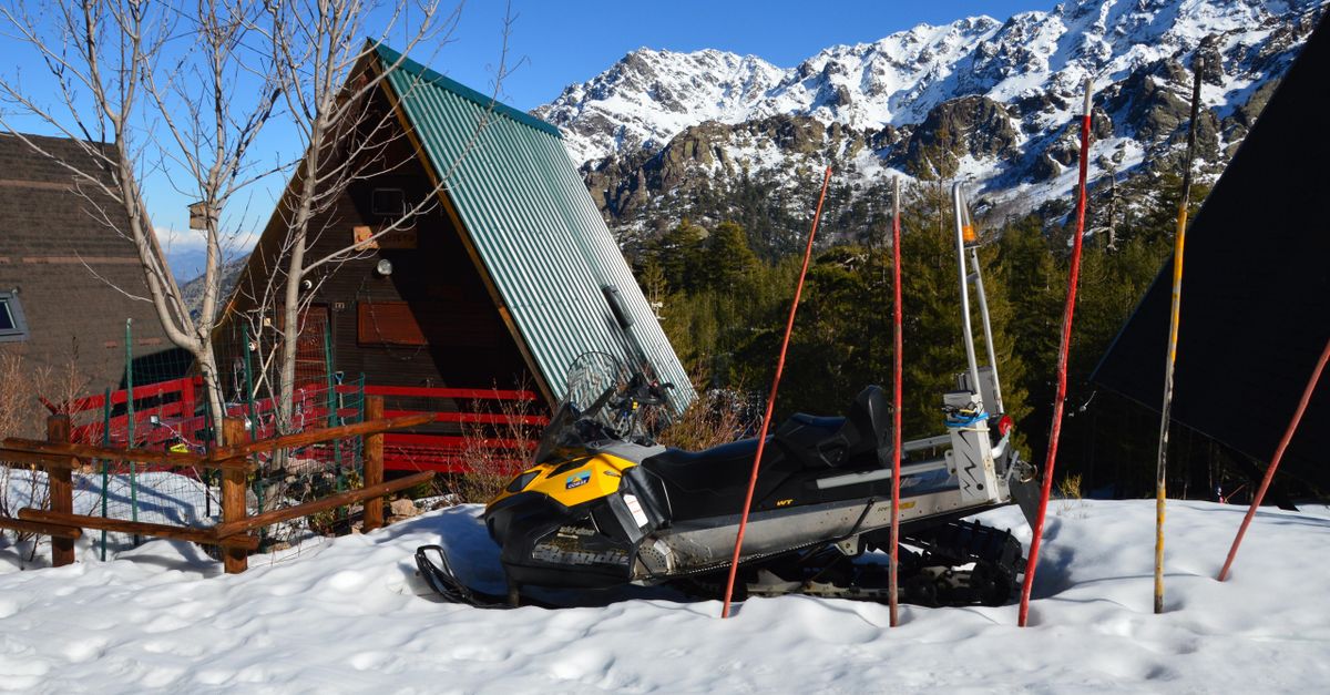 historic hot springs pool, snowy Idaho mountains, rustic log cabin winter, snowmobile trail forest