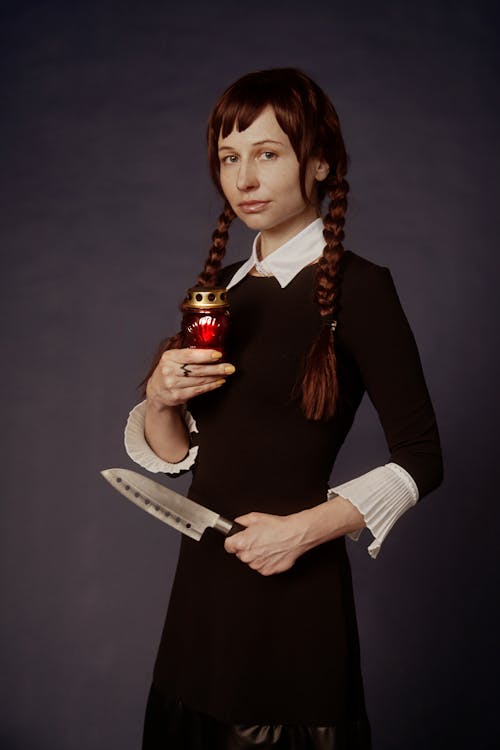 Woman Wearing Black Dress While Holding a Knife