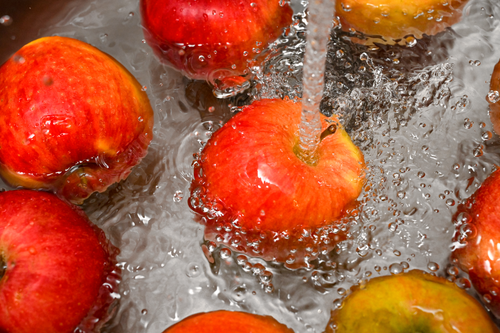 Free Vibrant red apples under a water stream, promoting cleanliness and freshness. Stock Photo