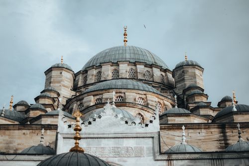 Free A stunning view of a historic mosque's intricate dome architecture under a cloudy sky. Stock Photo