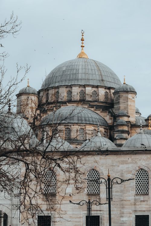 Free A beautiful view of an Ottoman-style mosque showcasing intricate domes and stonework. Stock Photo