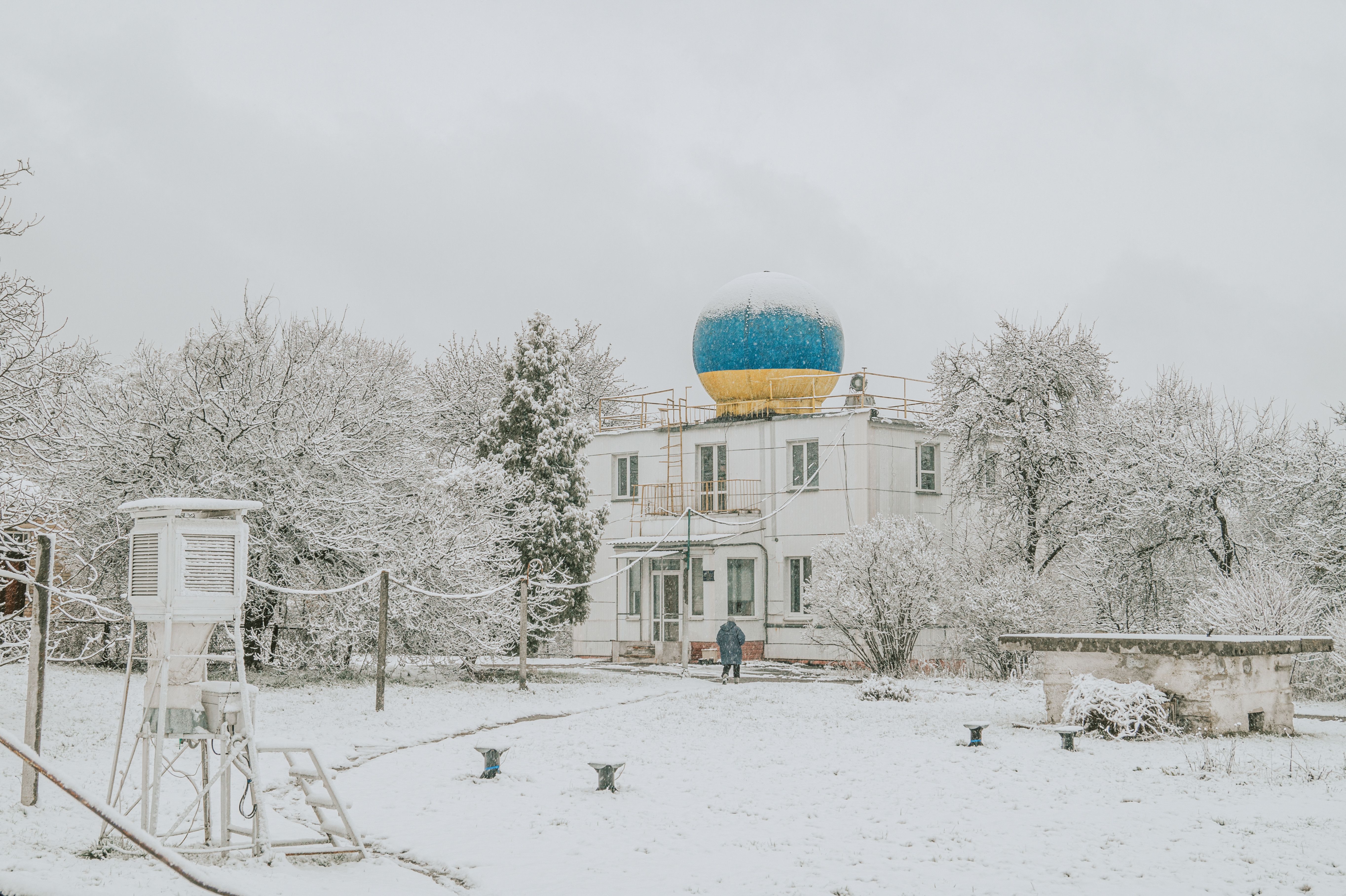 Serene winter scene with a snow-covered weather station and a blue dome in Kyiv, Ukraine.
