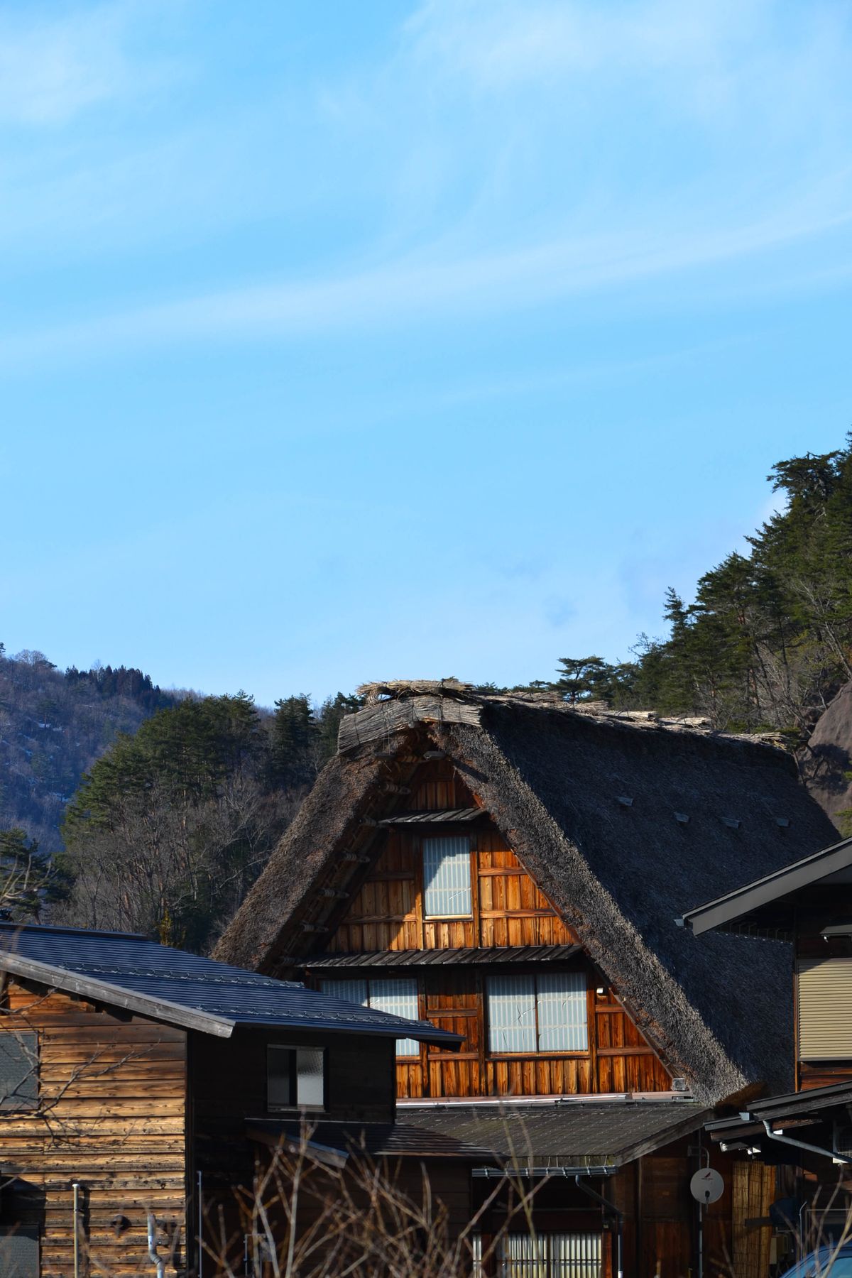 Scenic traditional Japanese thatched-roof house in a rural countryside setting under a clear sky