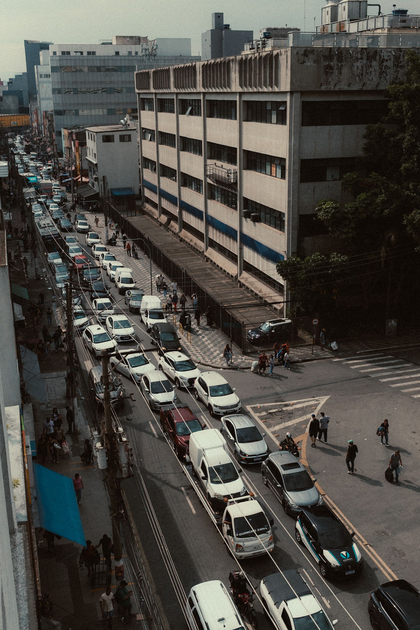 Busy urban street with traffic congestion captured from above, showcasing daily city life.