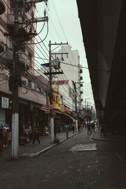 Free Urban street view featuring busy sidewalks, architectural buildings, and visible utility poles. Stock Photo