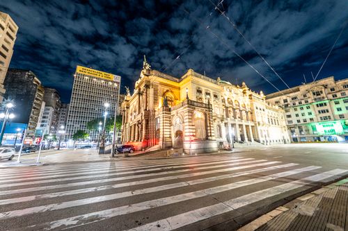 Free A beautifully illuminated historic building in an urban night setting, showcasing architecture and city life. Stock Photo