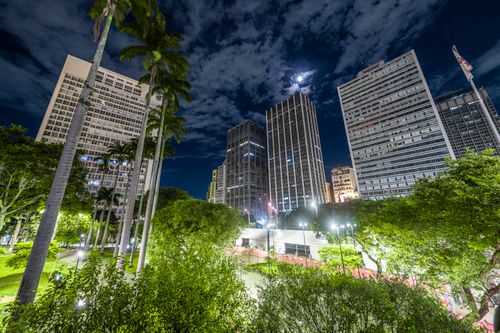 Free Night view of São Paulo's modern skyline showcasing illuminated skyscrapers and lush greenery. Stock Photo