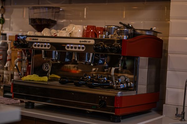 Close-up of a modern espresso machine with cups in a cozy cafe environment.