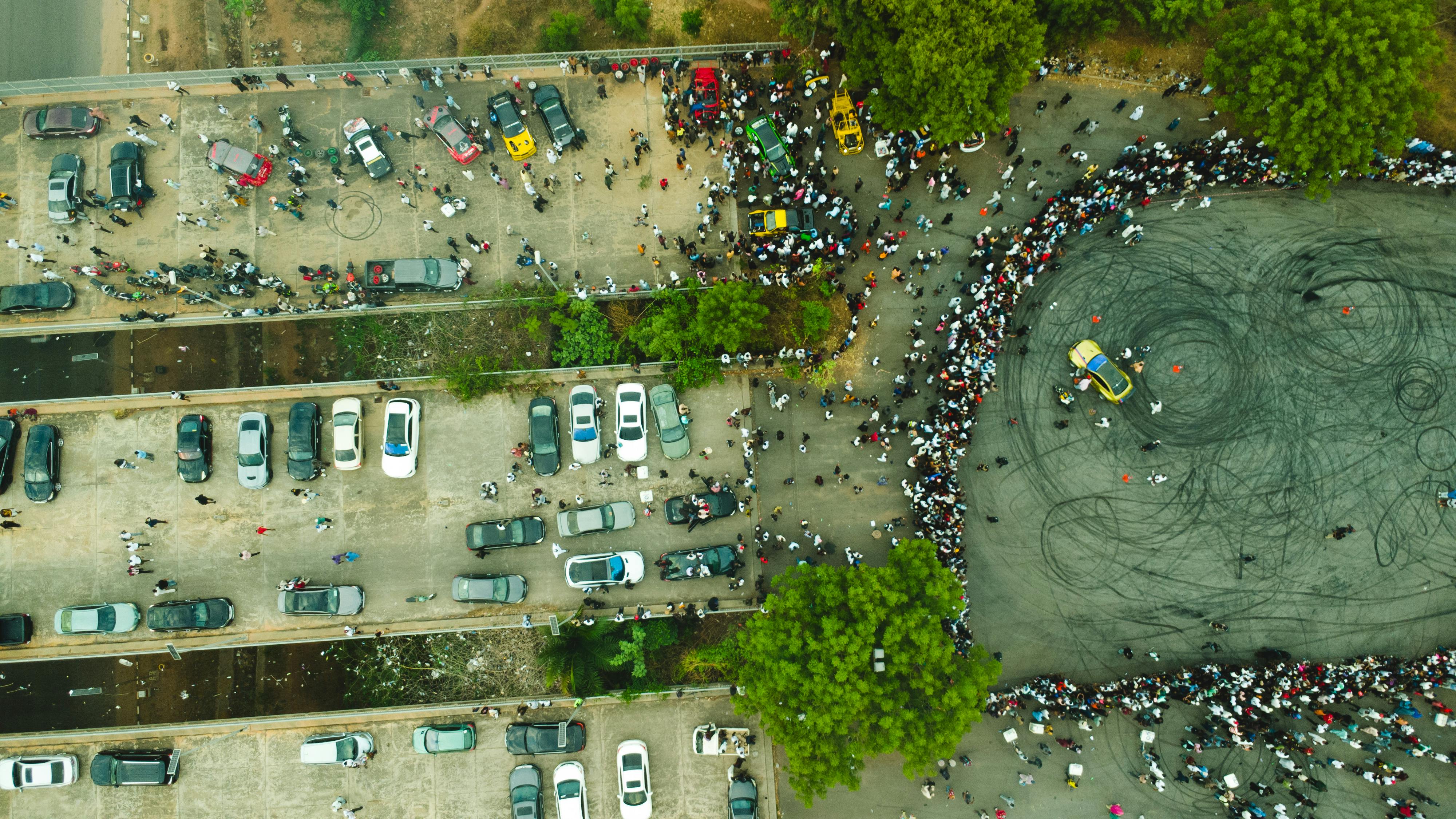 Aerial shot of a busy parking lot and large gathering in Abuja, Nigeria.
