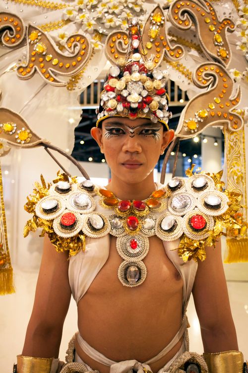 Free Person in ornate traditional costume and headpiece indoors. Stock Photo