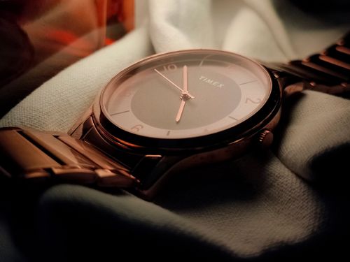 Free A stylish Timex watch with a golden bracelet band resting elegantly on soft fabric. Stock Photo