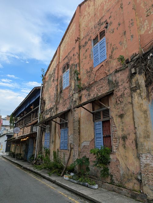 Free A vibrant street view of weathered buildings in Ipoh, showcasing historic architecture and colorful shutters. Stock Photo