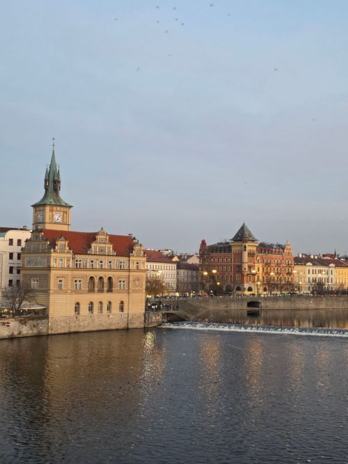 Free View of historic buildings along the Vltava River in Prague at twilight. Stock Photo