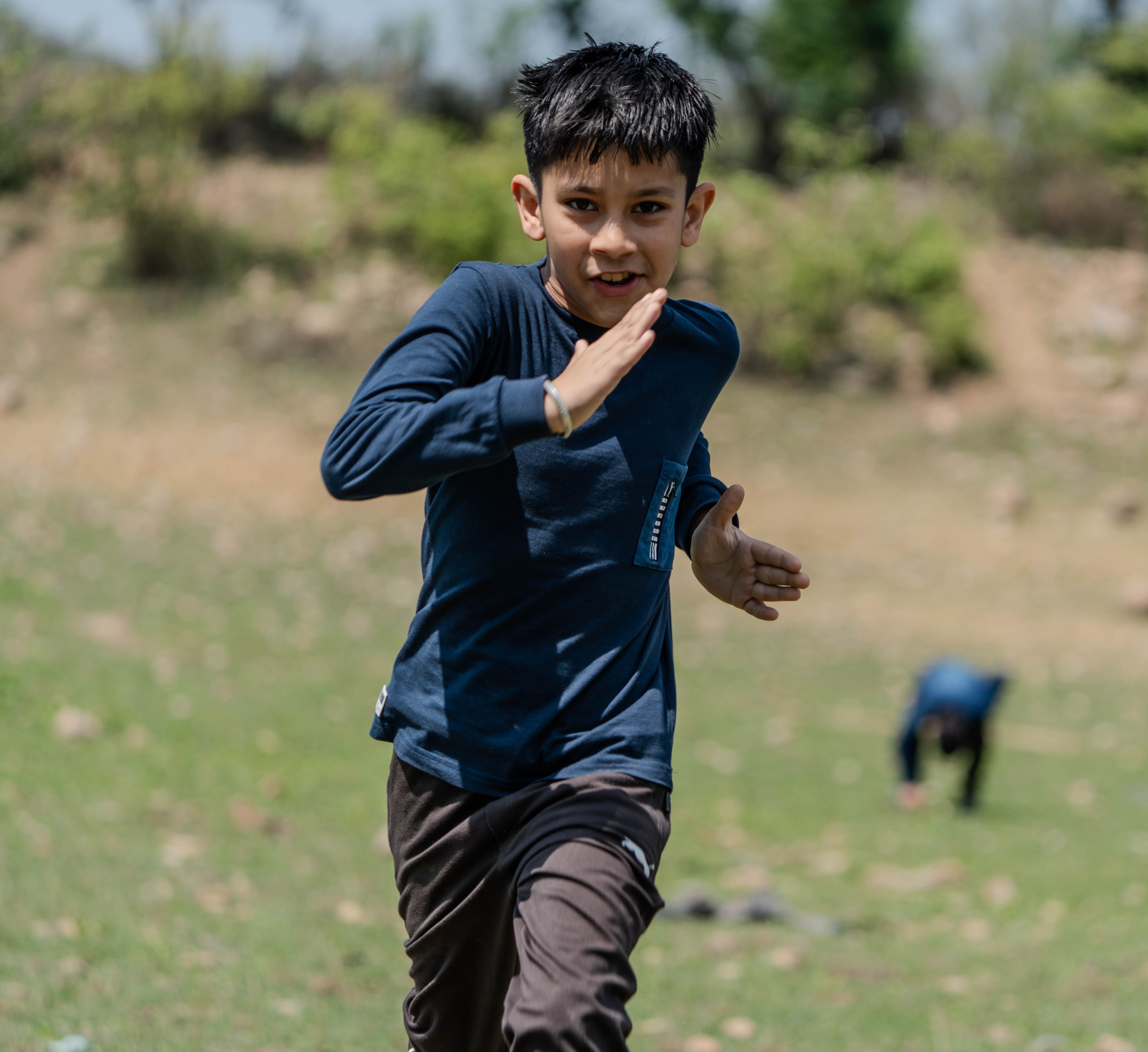 Energetic Young Boy Running in Open Field · Free Stock Photo