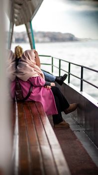 Women enjoying a peaceful ferry ride on the Bosphorus in Istanbul, Turkey, highlighting cultural diversity and tranquility.